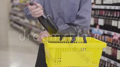 不知名的白种人从购物篮里拿出一瓶<strong>红酒</strong>，在镜头前<strong>展示</strong>。 无法辨认的成年人